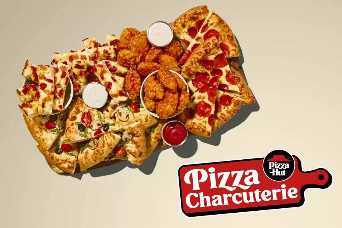 Una taula de xarcuteria de pizza amb diferents tipus de pizza, ales de pollastre i salses per acompanyar, disponible a Pizza Hut. Una taula de xarcuteria de pizza amb diferents tipus de pizza, ales de pollastre i salses per acompanyar, disponible a Pizza Hut.