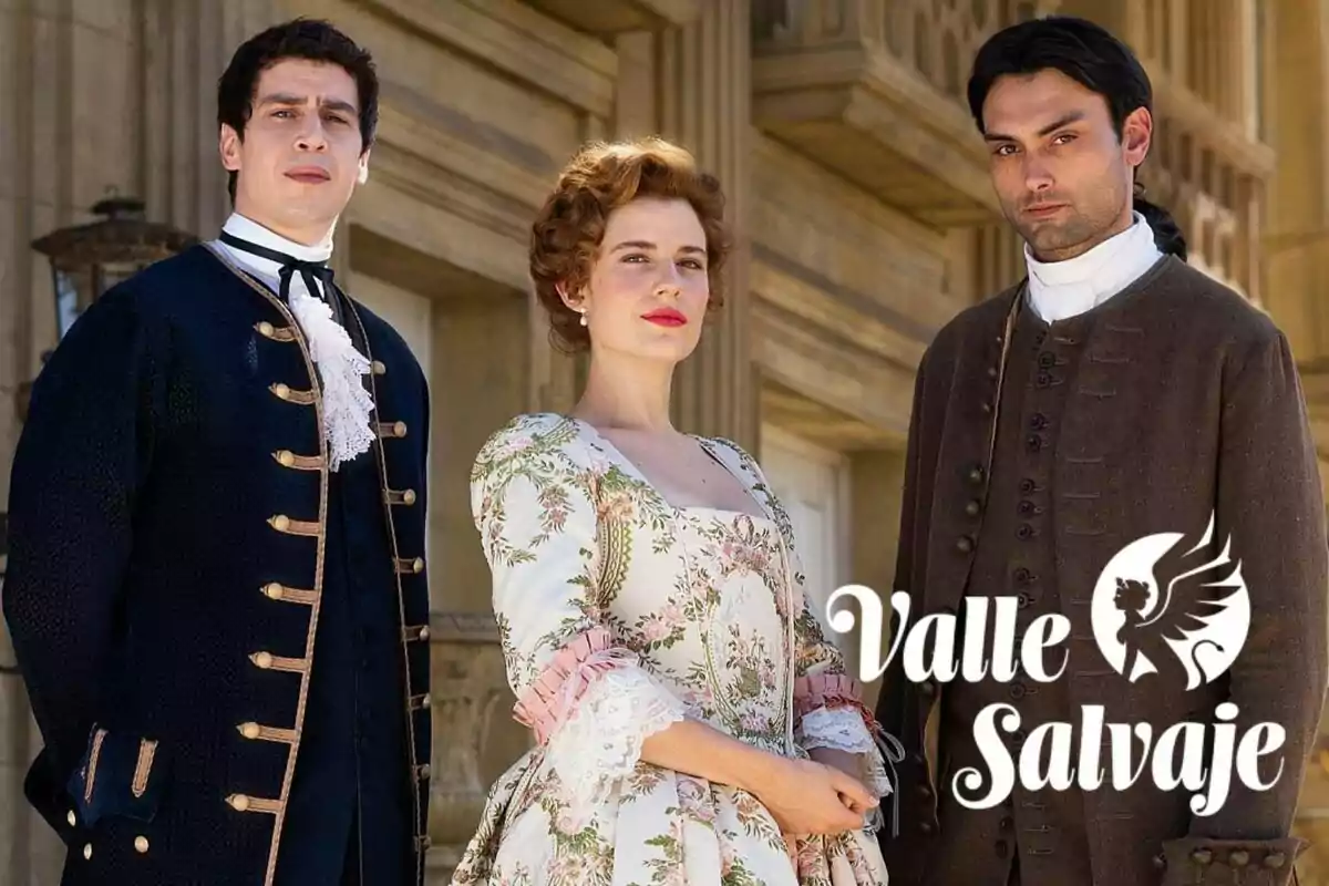 Nacho Olaizola, Rocío Suárez de Puga i Marco Pernas amb vestimenta d’època posen davant d’un edifici antic al costat del logotip de Valle Salvaje