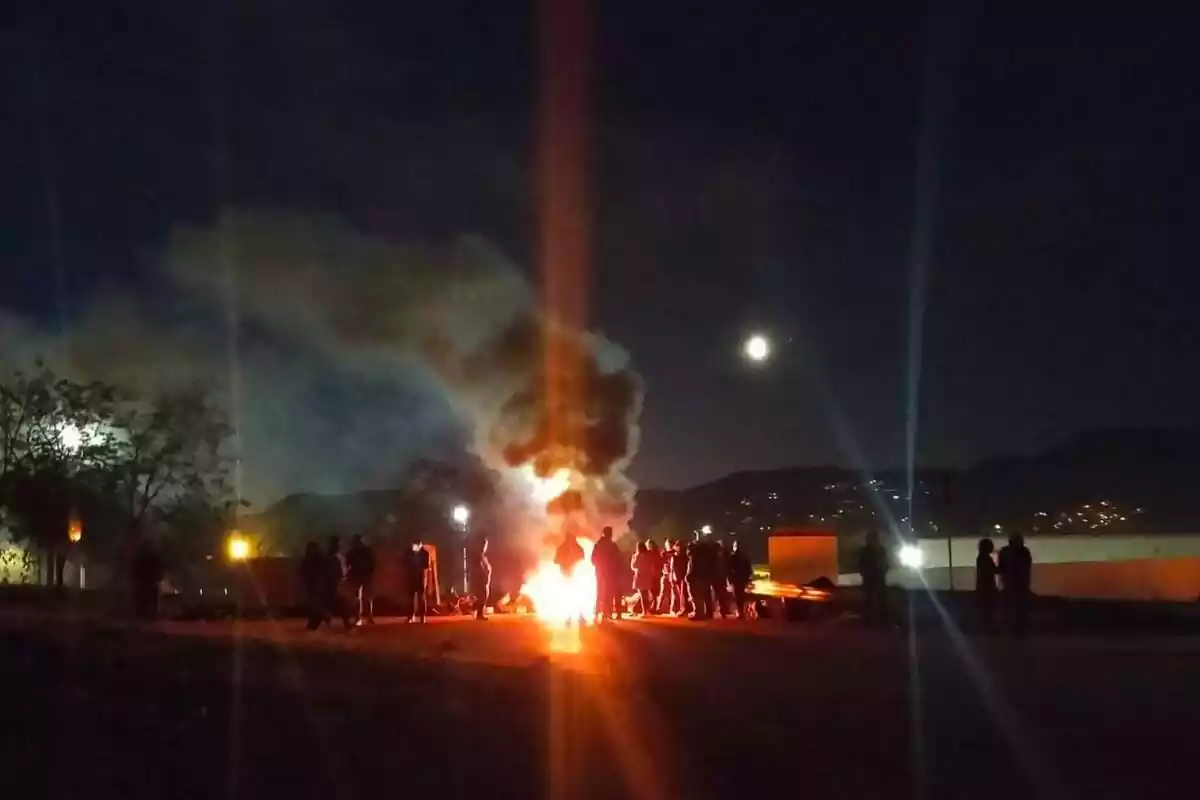 Dues dotzenes de treballadors de les presons catalanes munten una barricada amb una foguera als accessos de la presó de Brians