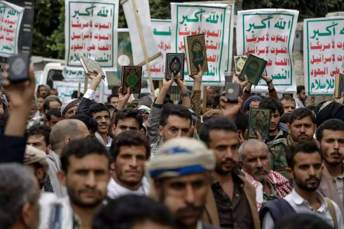Diversos manifestants al Iemen protesten per la crema d'un Alcorà a Suècia aixecant un Alcorà i diverses pancartes amb lletres verdes i vermelles en àrab