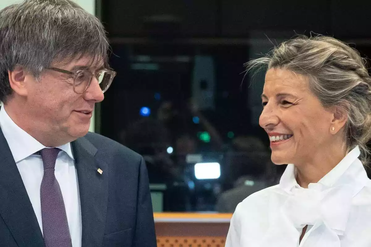 Pla mitjà de Carles Puigdemont i Yolanda Díaz mirant-se i somrient