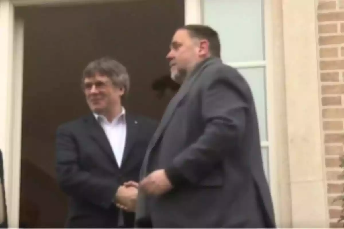 Junqueras i Puigdemont donant-se la mà davant de la casa de Puigdemont a Waterloo