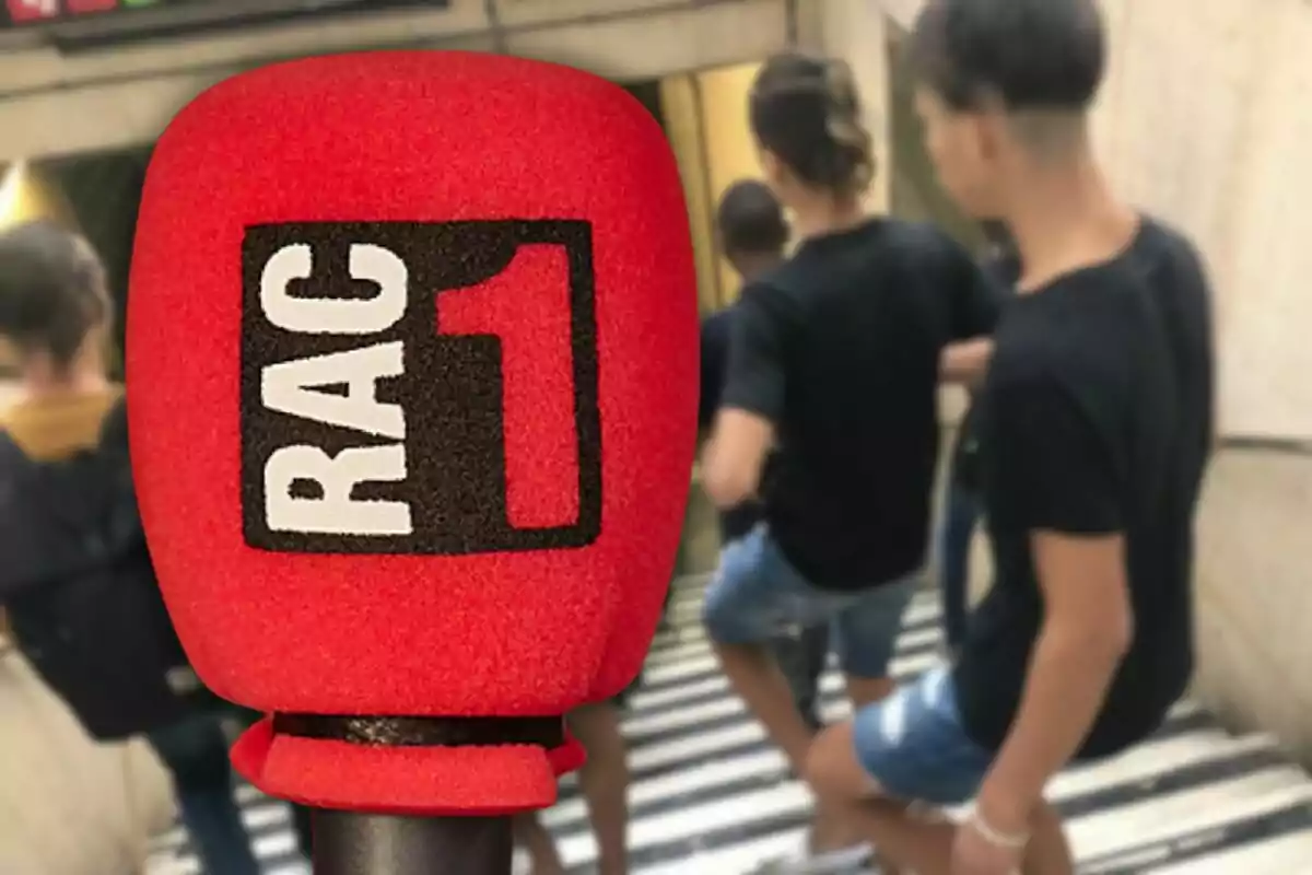 Micròfon vermell amb el logotip de RAC1 en primer pla i persones baixant escales al fons.