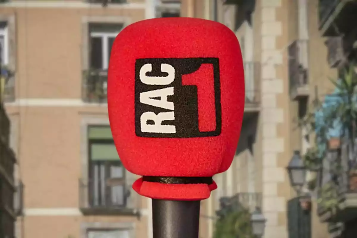 Micrófono rojo con el logotipo de RAC1 en un entorno urbano.