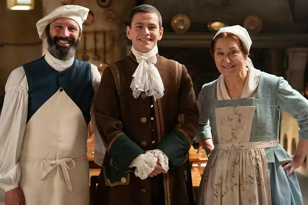 Chiqui Fernández, César Maroto i Rafa Álamos vestides amb vestits d'època posen somrient en un ambient que sembla ser una cuina antiga a Valle Salvaje. Chiqui Fernández, César Maroto i Rafa Álamos vestides amb vestits d'època posen somrient en un ambient que sembla ser una cuina antiga a Valle Salvaje.