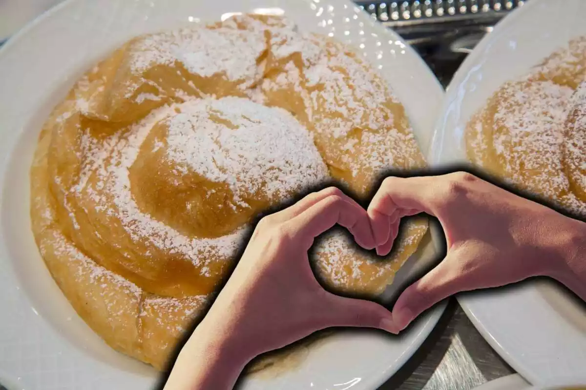 Mans formant un cor sobre fons de dues ensaïmades en plats blancs