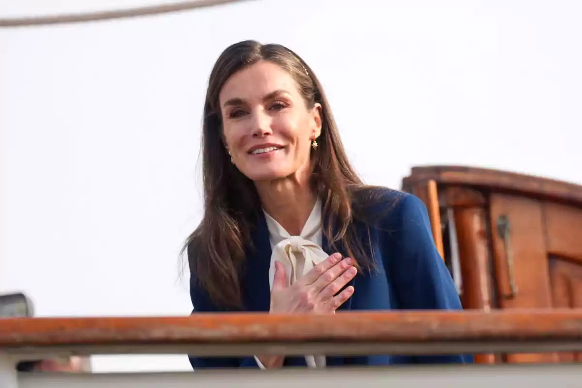 Letizia con la mano en el pecho mientras está de pie en un barco.