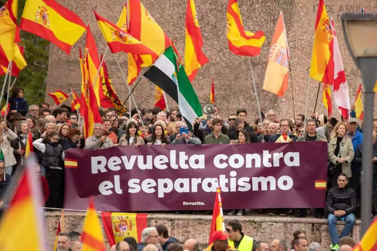 Desenes de manifestants amb banderes espanyoles darrere d'una pancarta amb el lema 'revolta contra el separatisme'