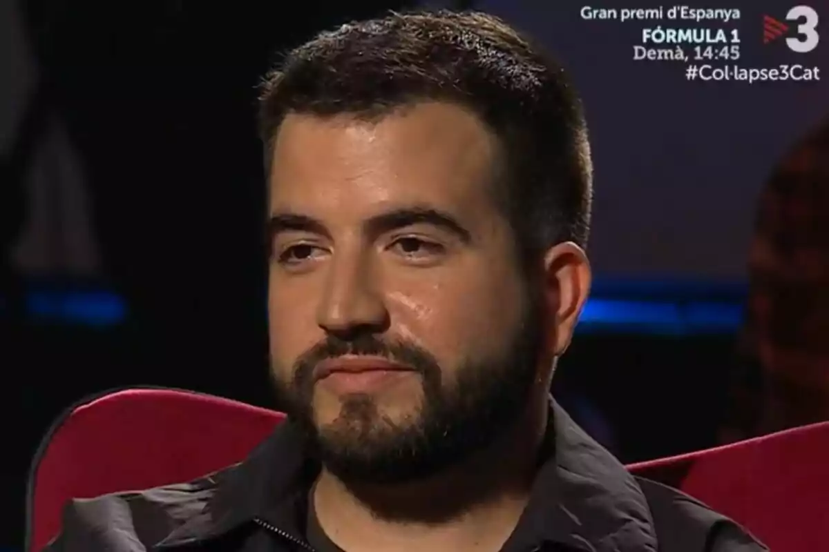 Ricard Ustrell de barba i cabell curt assegut en un sofà vermell amb expressió seriosa en un estudi de televisió a Col·lapse de TV3