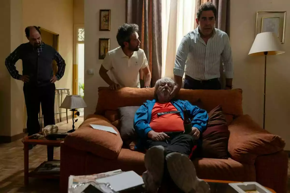 Jordi Sánchez, Pablo Chiapella y Raúl Peña están en una sala junto a Ricardo Arroyo que está sentado en un sofá con una botella en la mano mientras los otros lo observan de pie en La que se avecina.