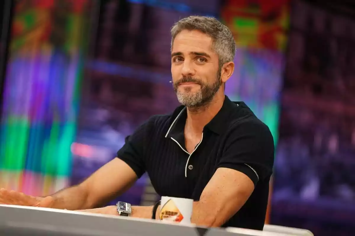 Roberto Leal de cabell curt i barba assegut en una taula d’El Hormiguero amb un fons acolorit i una tassa blanca Roberto Leal de cabell curt i barba assegut en una taula d’El Hormiguero amb un fons acolorit i una tassa blanca