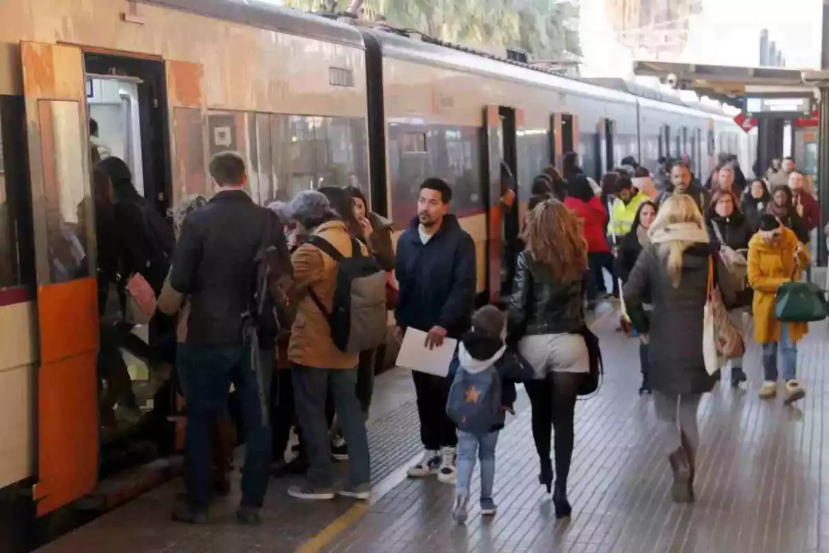 Imagen de varias personas entrando en un tren de Rodalies