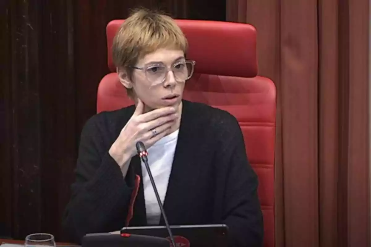 Pla mitjà de Rosa Romà en asseguda a la tribuna de la comissió de control de la Corpo al Parlament de Catalunya, tocant-se la barbeta