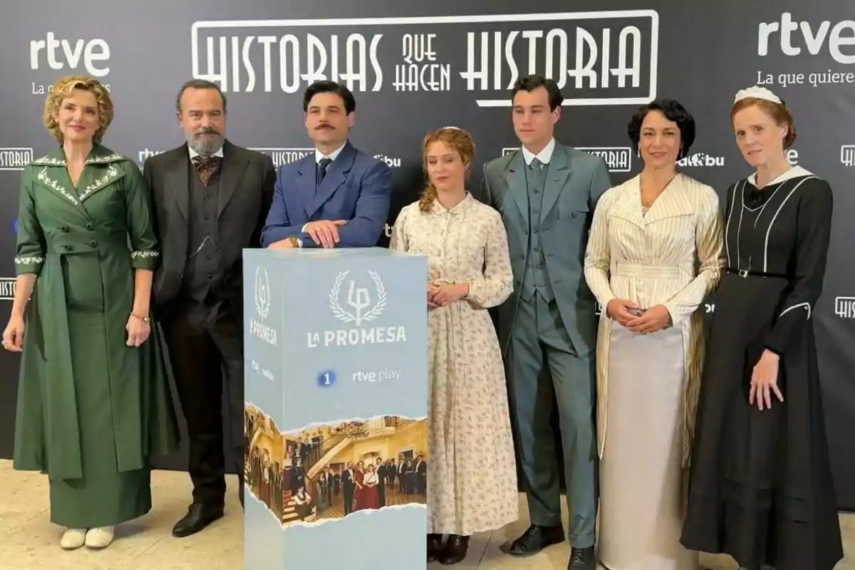 Un grup de persones com Eva Martín, Manuel Regueiro, Arturo Sancho, Ana Garcés o María Castro posant davant d'un fons promocional de "Històries que fan història" i "La Promesa" de RTVE, amb vestimenta d'època.