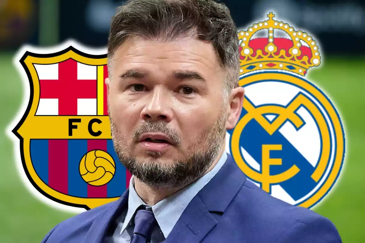 Un home amb barba i vestit està davant dels escuts del FC Barcelona i el Reial Madrid.