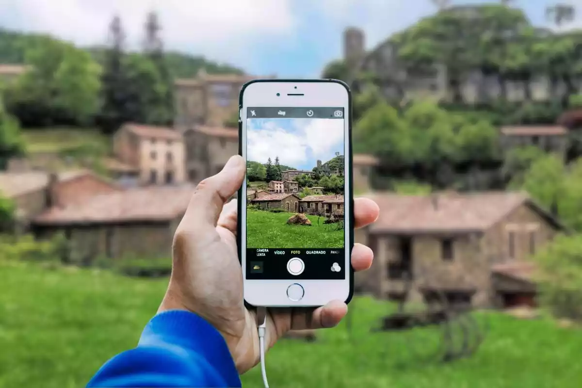 Fotomuntatge d'una persona fent una foto al paisatge de Rupit