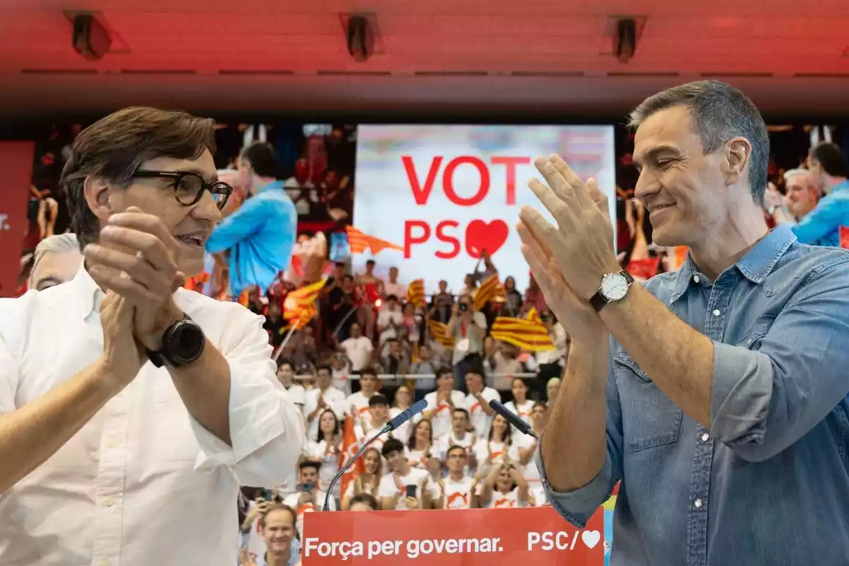 Salvador Illa i Pedro Sánchez mirant-se als ulls somrients en un acte del PSC