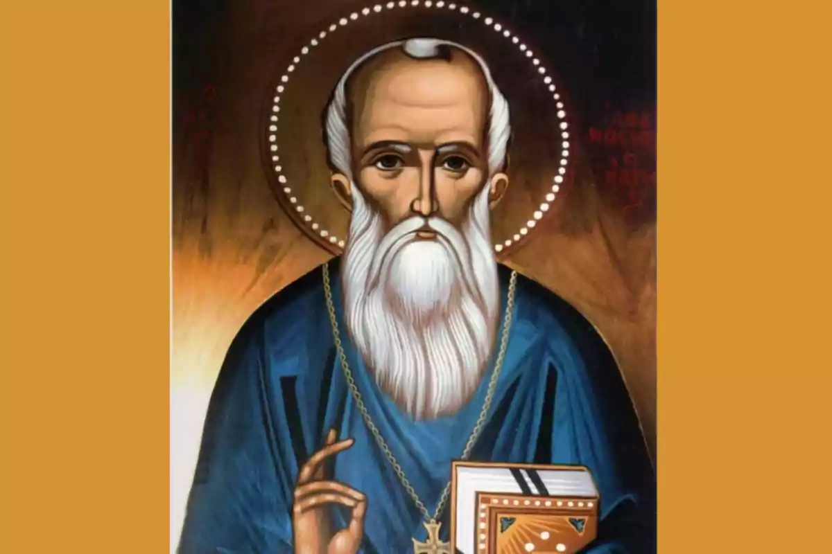 Icona religiosa d'un sant amb aurèola, barba blanca i túnica blava, sostenint un llibre i fent un gest de benedicció. Icona religiosa d'un sant amb aurèola, barba blanca i túnica blava, sostenint un llibre i fent un gest de benedicció.