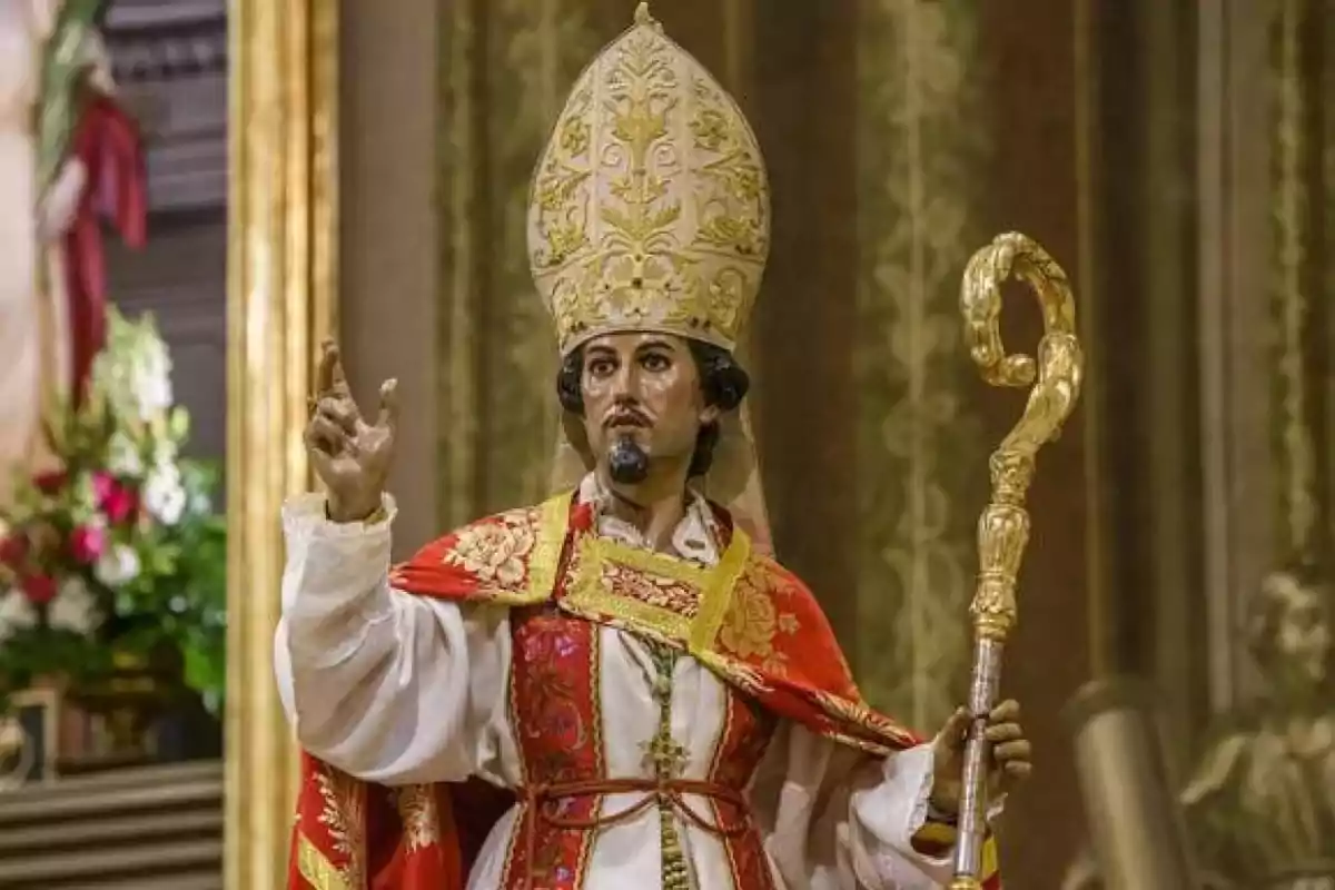 A religious statue of a bishop in ceremonial robes and carrying a golden crosier.