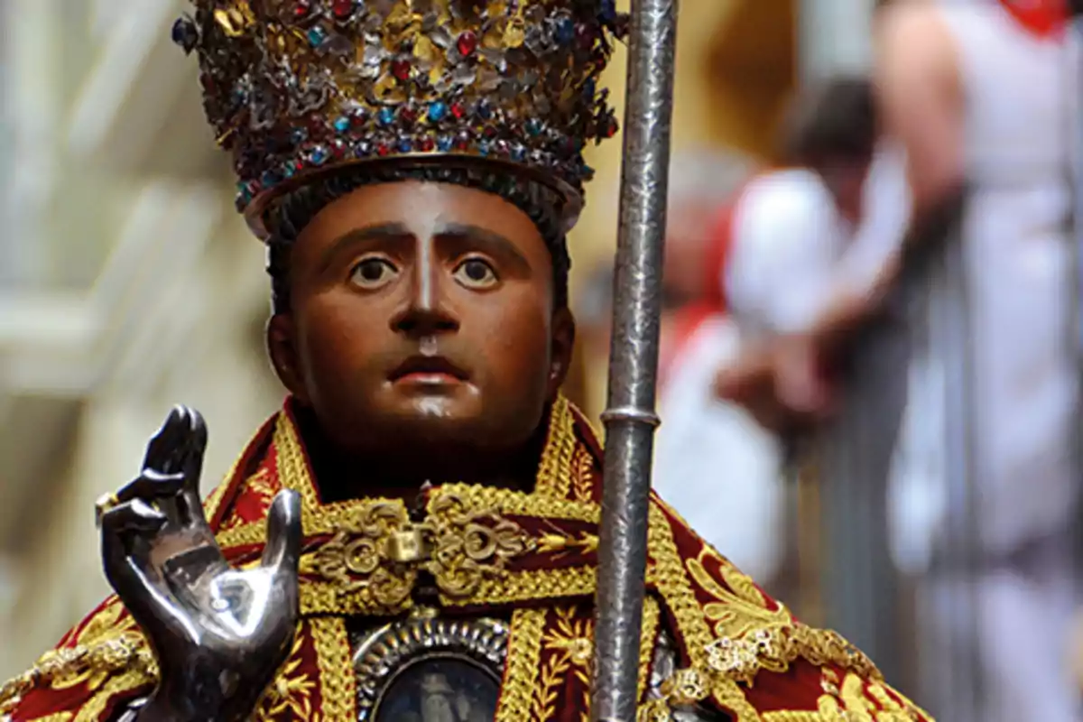 Una estàtua religiosa amb vestimenta elaborada i una corona adornada amb joies.