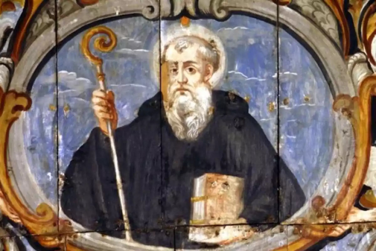 Pintura religiosa d’un home amb barba blanca vestit amb una túnica fosca sostenint un bàcul en una mà i un llibre a l’altra, envoltat d’un marc decoratiu Pintura religiosa d’un home amb barba blanca vestit amb una túnica fosca sostenint un bàcul en una mà i un llibre a l’altra, envoltat d’un marc decoratiu