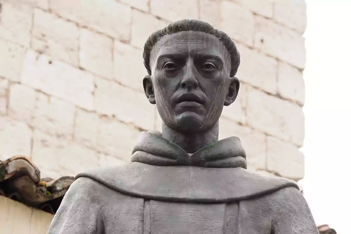 Una estàtua d'un monjo amb caputxa davant d'una paret de maons. Una estàtua d'un monjo amb caputxa davant d'una paret de maons.