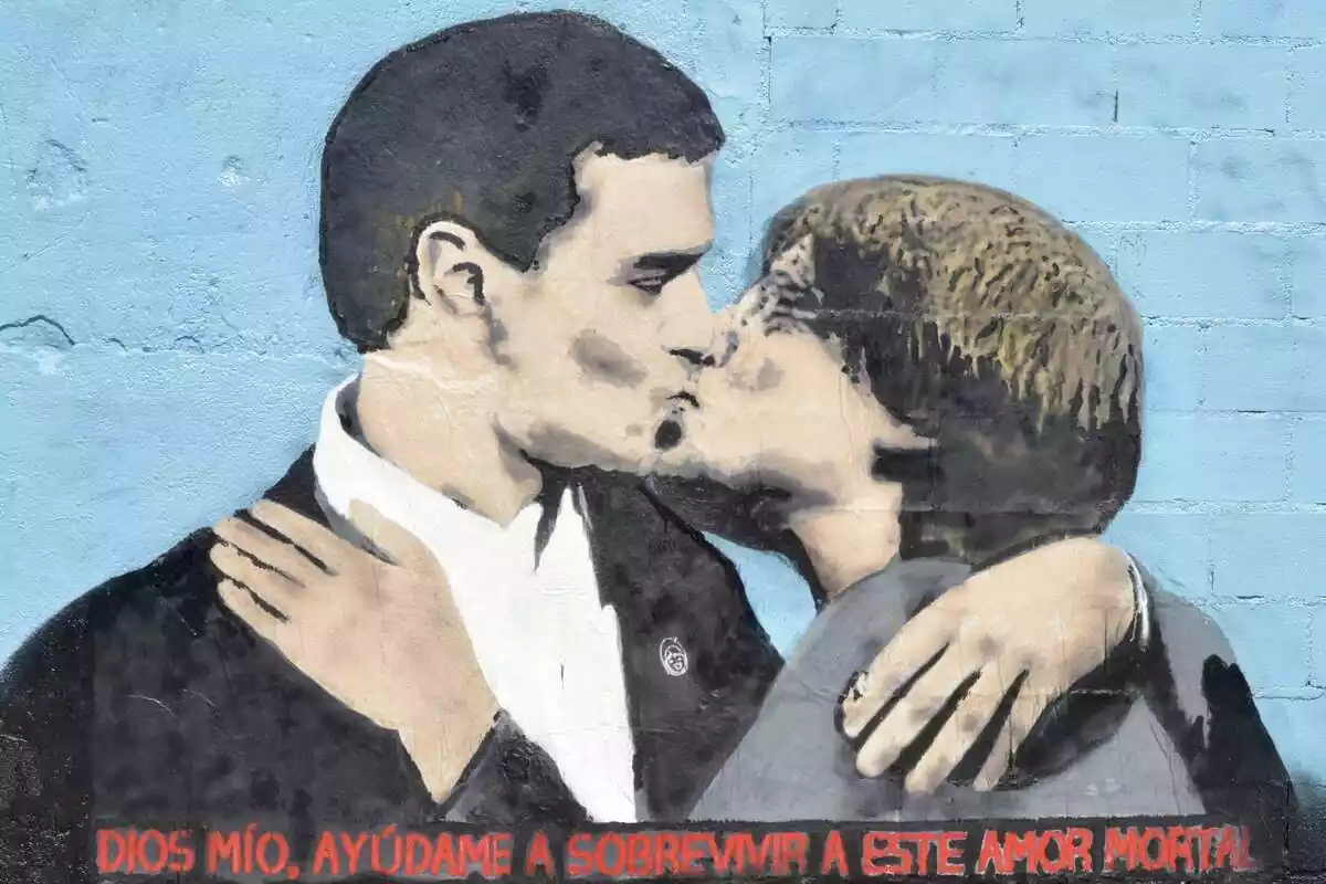 Graffitti de Tvboy de Pedro Sánchez i Carles Puigdemont fent-se un petó a la boca