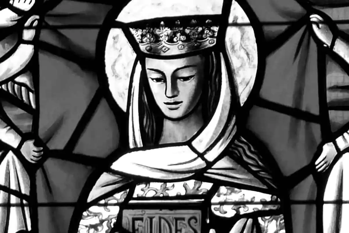 Vitrall en blanc i negre que mostra una figura femenina amb corona i halo, sostenint un llibre amb la paraula Vitrall en blanc i negre que mostra una figura femenina amb corona i halo, sostenint un llibre amb la paraula