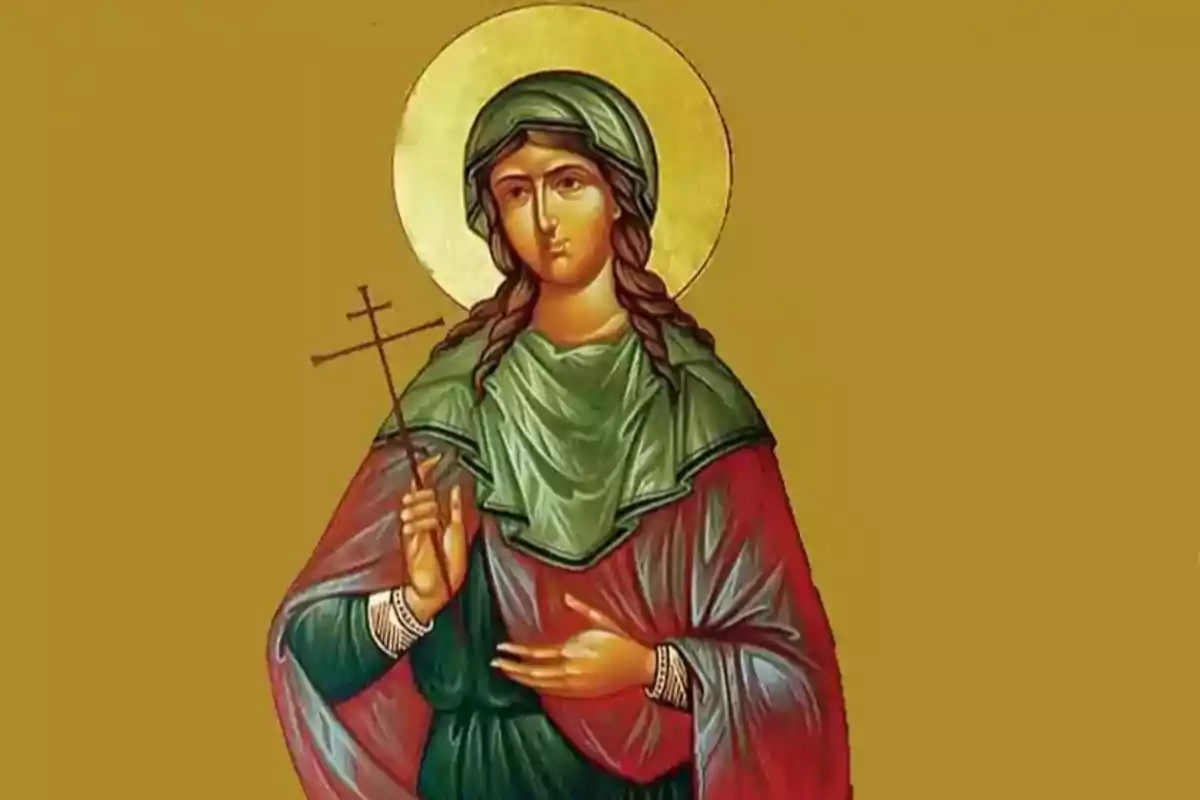 Una imagen de un icono religioso que muestra a una figura femenina con un halo dorado, sosteniendo una cruz en su mano derecha y vistiendo ropas de colores verde y rojo.