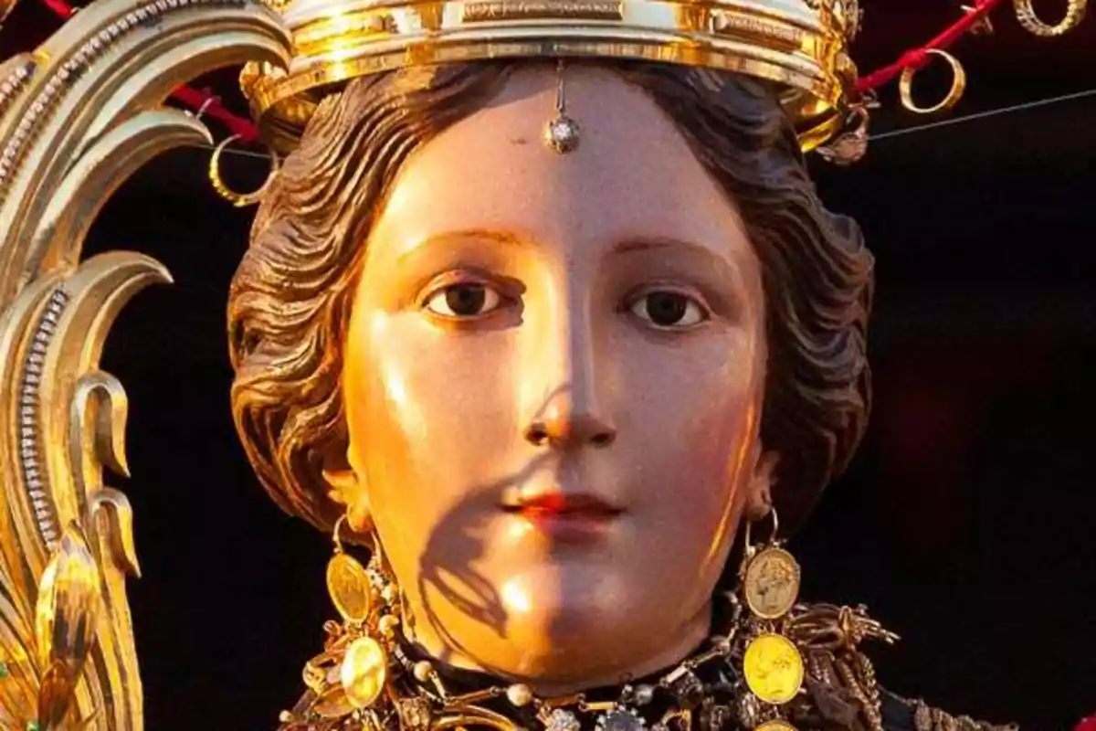 Una estàtua religiosa amb una corona daurada i adornaments detallats. Una estàtua religiosa amb una corona daurada i adornaments detallats.