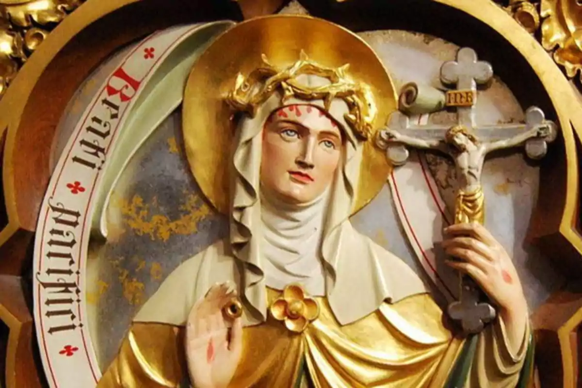Una escultura religiosa d'una figura femenina amb aureola daurada, corona d'espines i un crucifix a la mà. Una escultura religiosa d'una figura femenina amb aureola daurada, corona d'espines i un crucifix a la mà.
