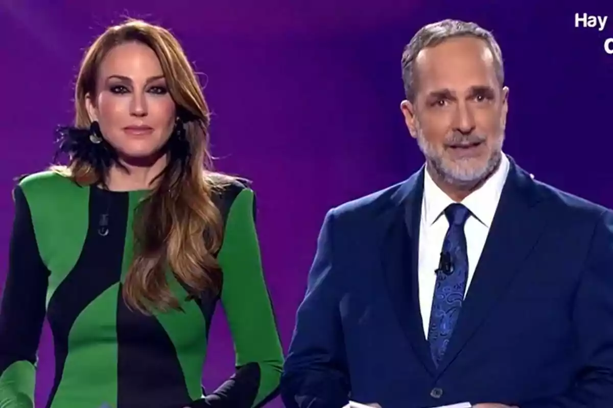 Beatriz Archidona y Santi Acosta en un escenario con fondo morado, ella lleva un vestido verde y negro y él un traje azul en De Viernes.