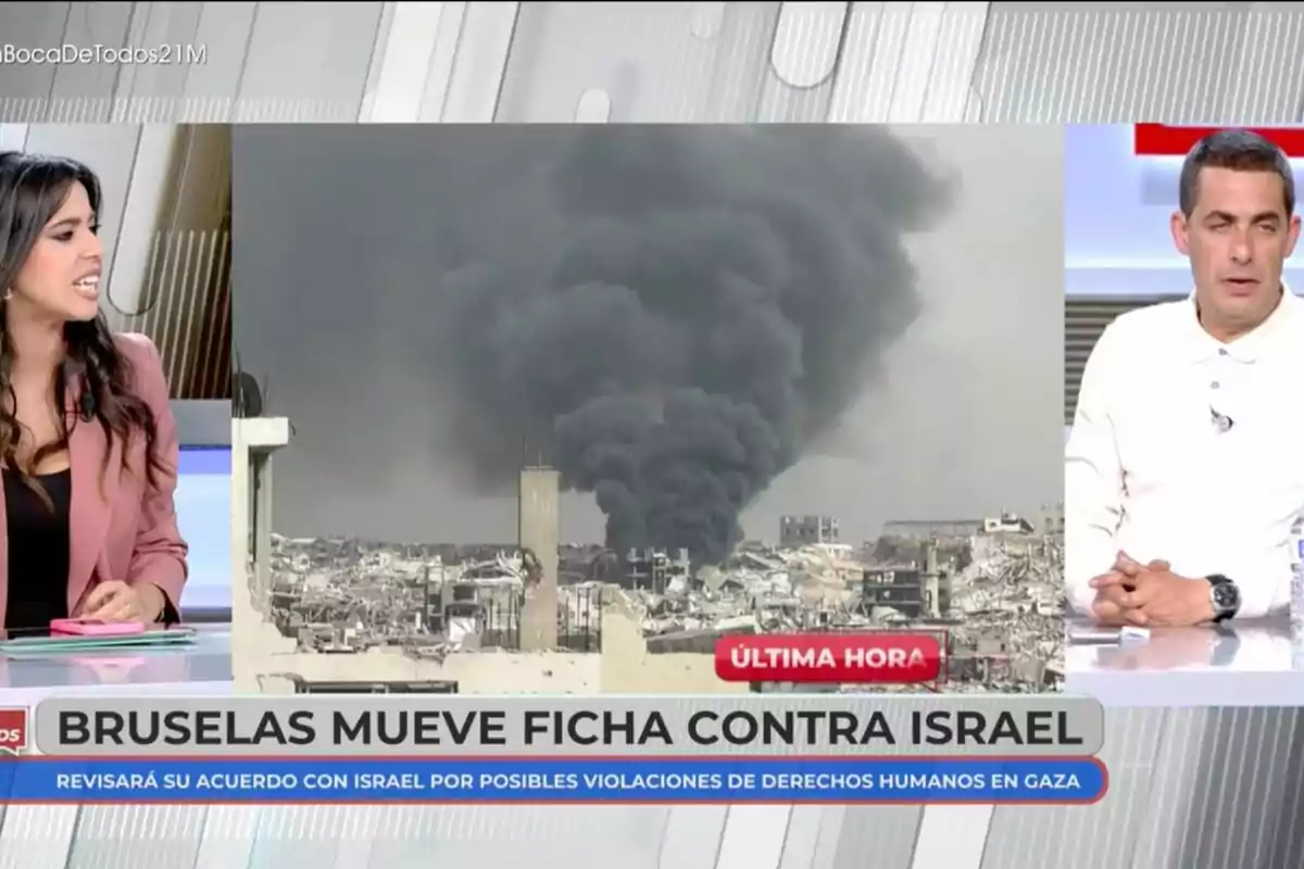 Sarah Santaolalla i Antonio Naranjo discuteixen sobre una notícia d'última hora que mostra una imatge de fum negre elevant-se sobre una ciutat, amb el titular Sarah Santaolalla i Antonio Naranjo discuteixen sobre una notícia d'última hora que mostra una imatge de fum negre elevant-se sobre una ciutat, amb el titular