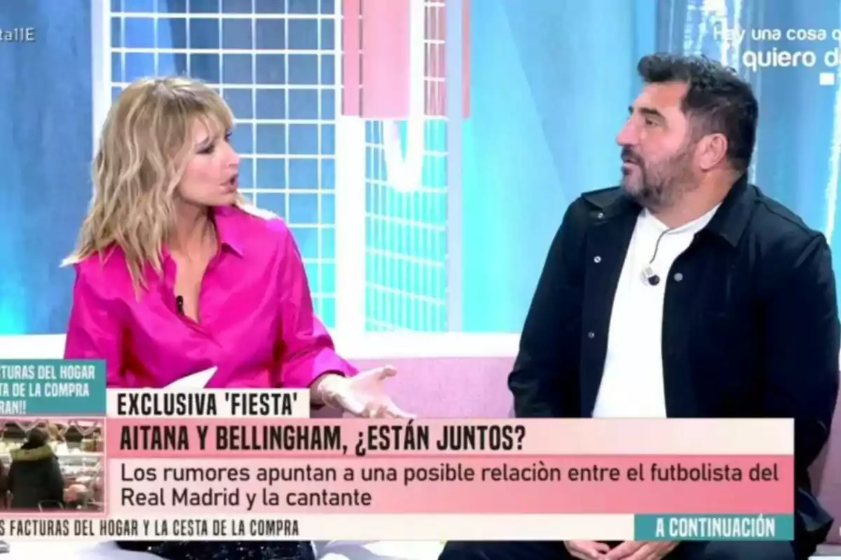 Emma García amb brusa rosa conversa amb Sergio Garrido vestit de negre en un Festa, mentre que a la pantalla es mostra un titular sobre rumors d'una possible relació entre un futbolista i una cantant.