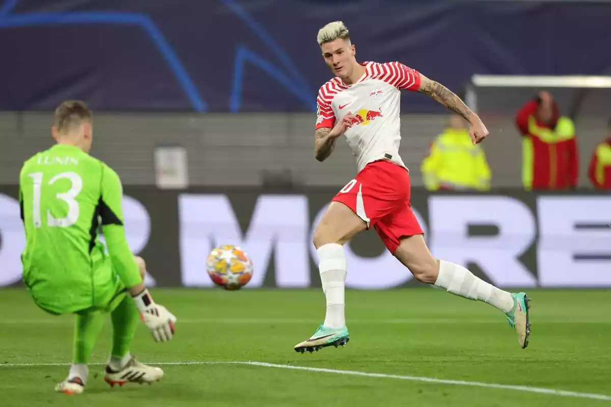 Benjamin Sesko shooting on goal with Andriy Lunin stopping the shot