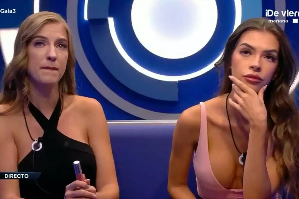 Lucía i Silvia assegudes al confessionari de Gran Hermano, una amb vestit negre i l'altra amb vestit rosa, totes dues amb expressions serioses.