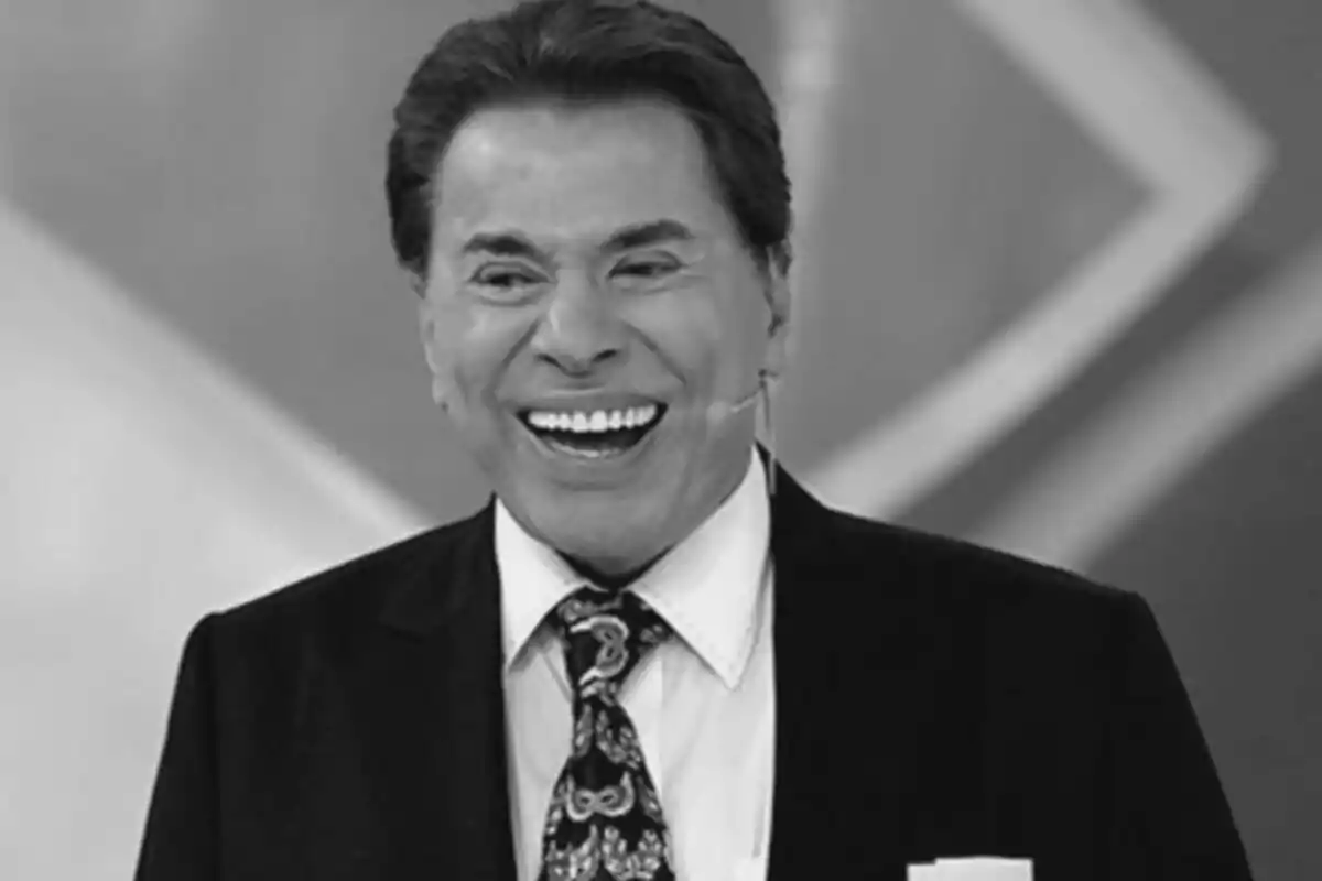 Fotografia en blanc i negre de Silvio Santos somrient amb vestit i corbata