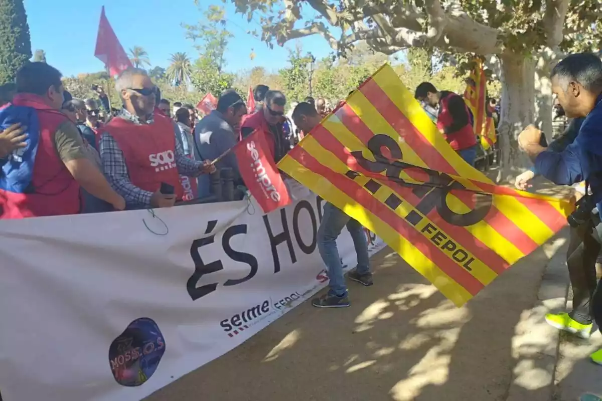 Diversos sindicalistes dels Mossos protestes a les portes del Parlament amb banderes i petos del sindicat, una senyera i una pancarta