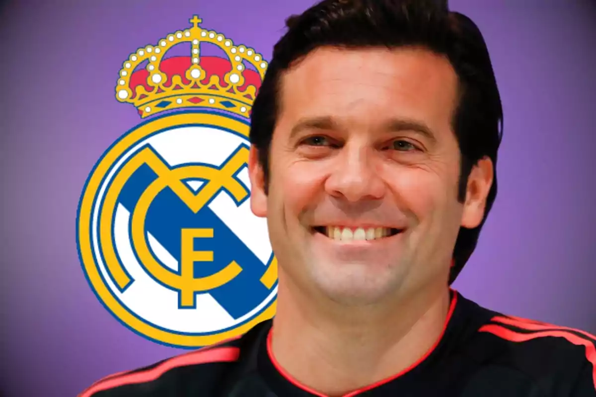 A smiling man with the Real Madrid crest in the background.