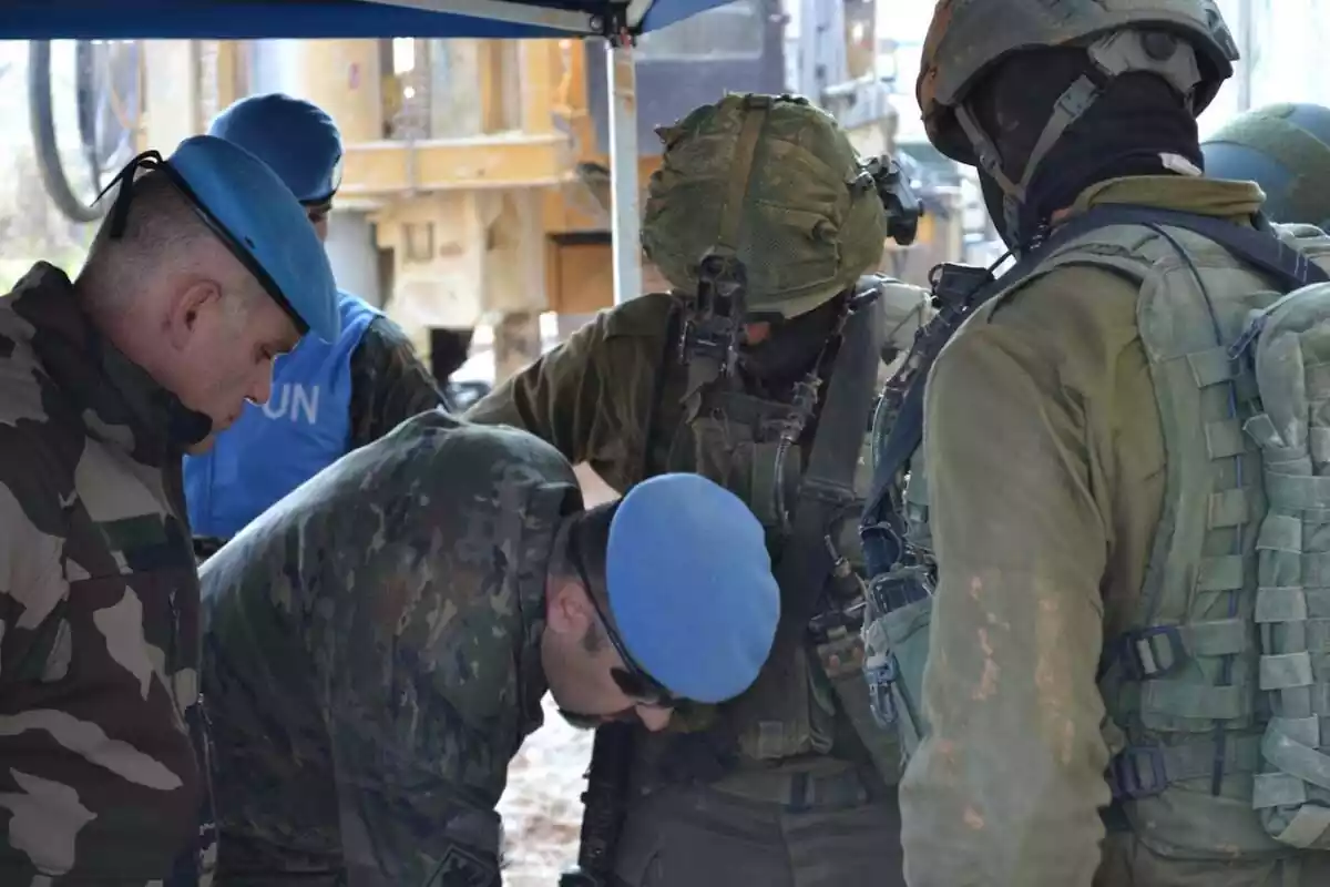 Dos oficials de les Nacions Unides, un francès i un espanyol, revisen unes perforacions en presència de soldats israelians del Batalló Yahalom