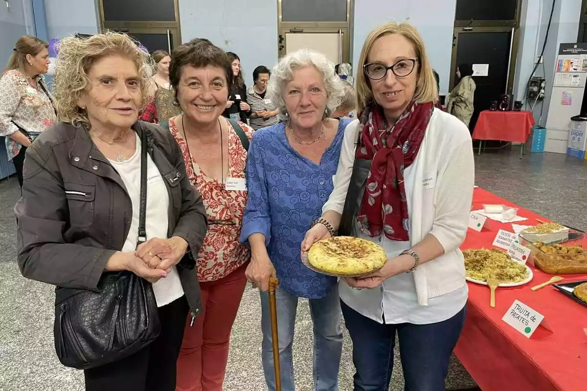 Imatge d´un grup de dones mostrant un plat de truita a la cambra