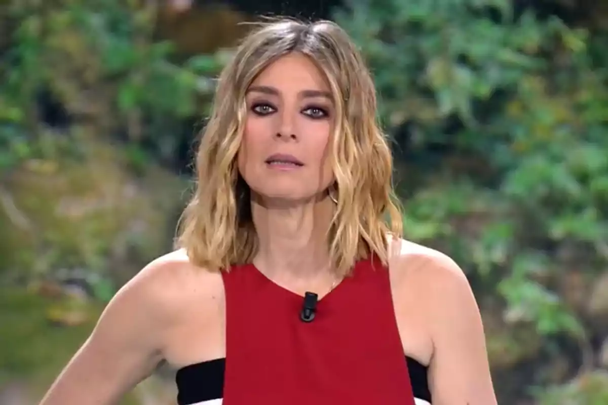 Sandra Barneda porta un vestit vermell i negre davant d'un fons verd difuminat. Captura de 'Supervivientes'.