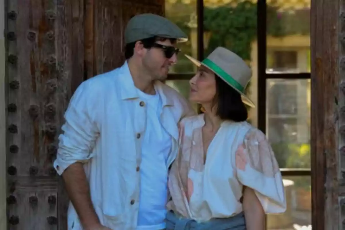 A couple—Íñigo Onieva and Tamara Falcó—looking at each other affectionately while posing together outdoors in front of a wooden door. A couple—Íñigo Onieva and Tamara Falcó—looking at each other affectionately while posing together outdoors in front of a wooden door.
