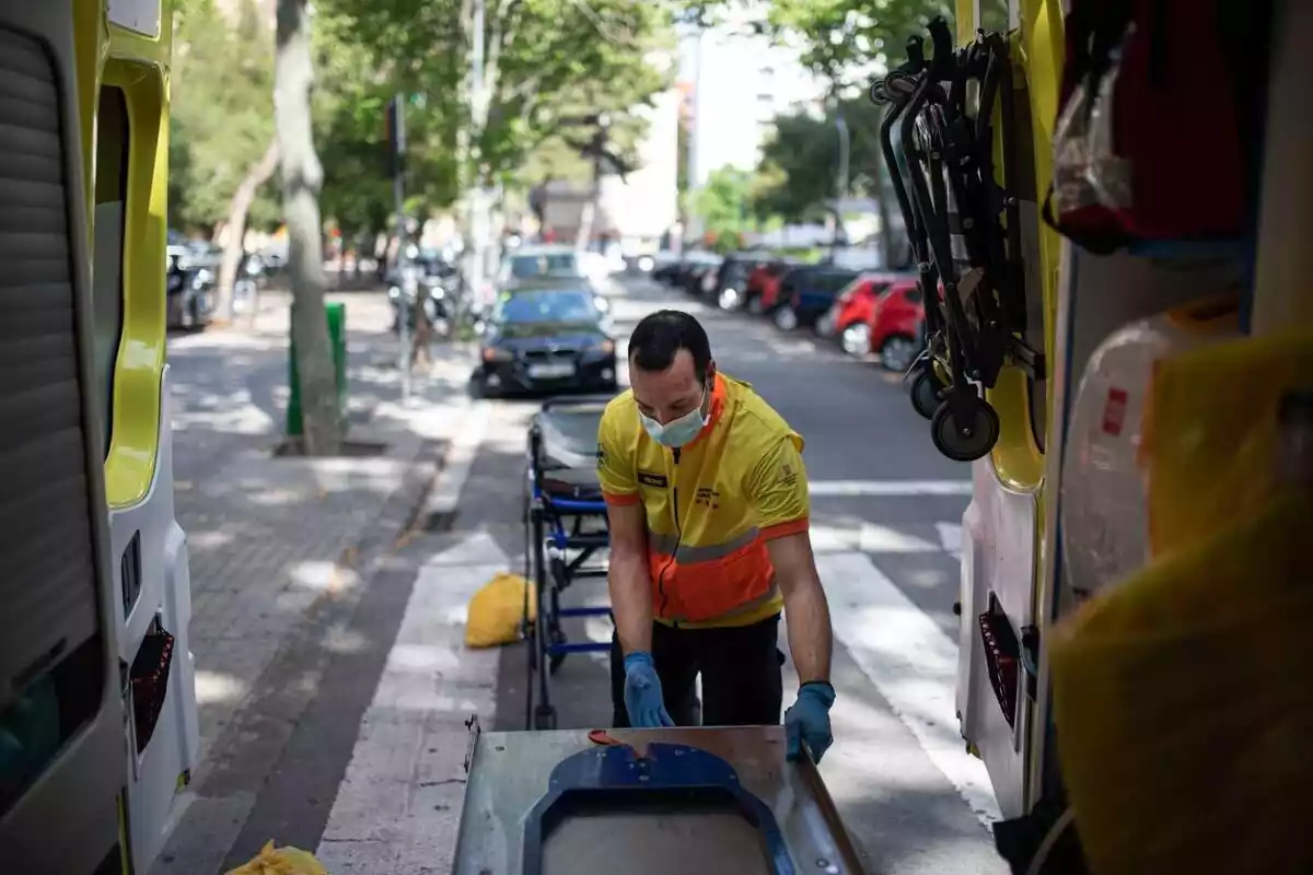 Un tècnic del Sistema d'Emergències Mèdiques (SEM) de la Generalitat de Catalunya fica una camilla en una ambulància durant un servei