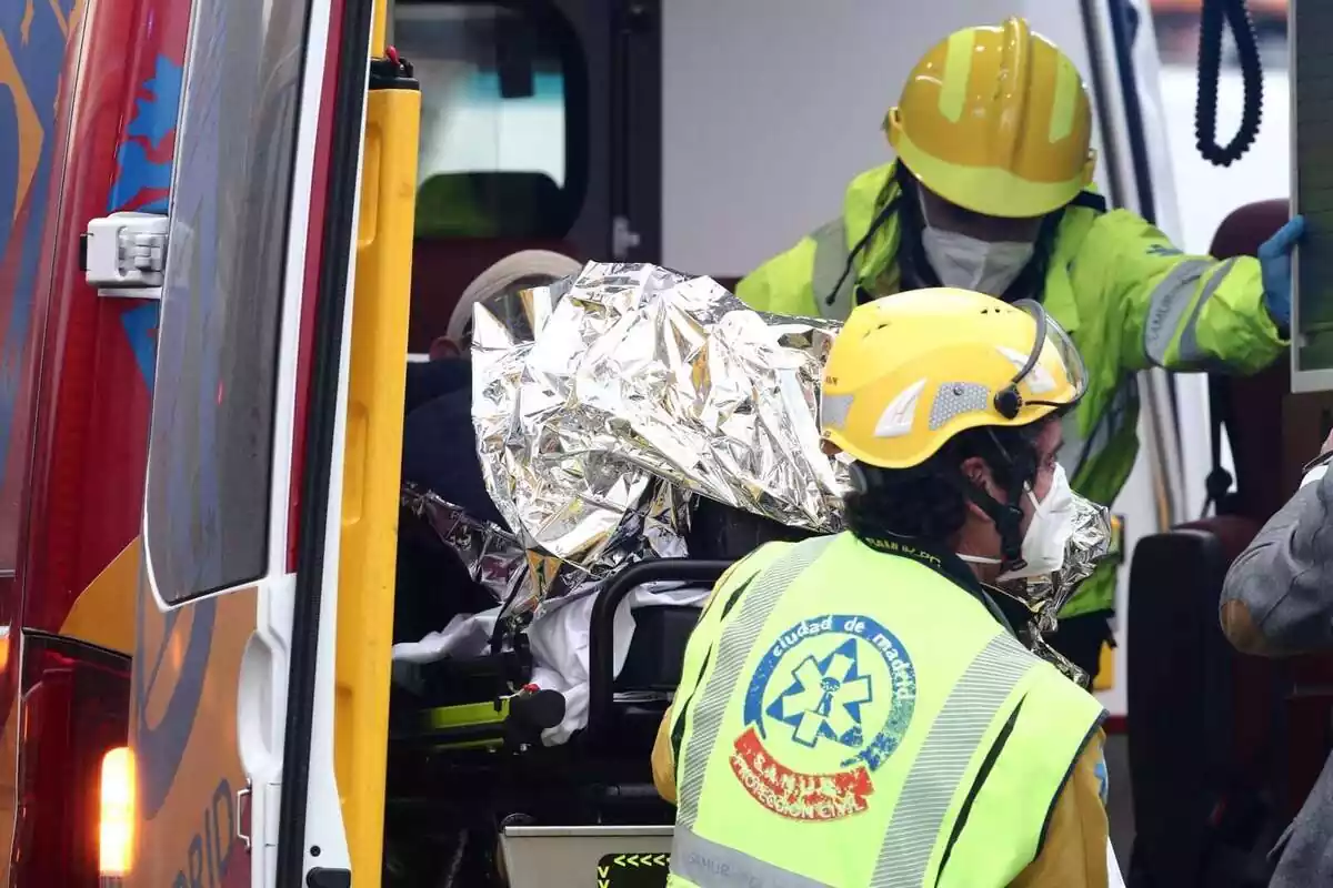 Diversos treballadors sanitaris introdueixen un ferit en una ambulància a Madrid (Espanya)