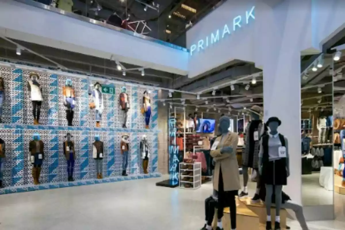 Botiga de roba amb maniquins i un rètol de Primark il·luminat. Botiga de roba amb maniquins i un rètol de Primark il·luminat.