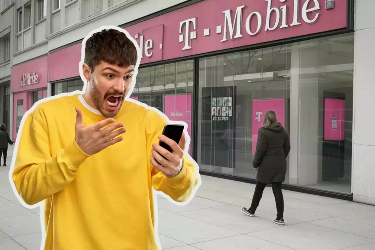 A man in a yellow sweater looks surprised while looking at his phone in front of a T-Mobile store.
