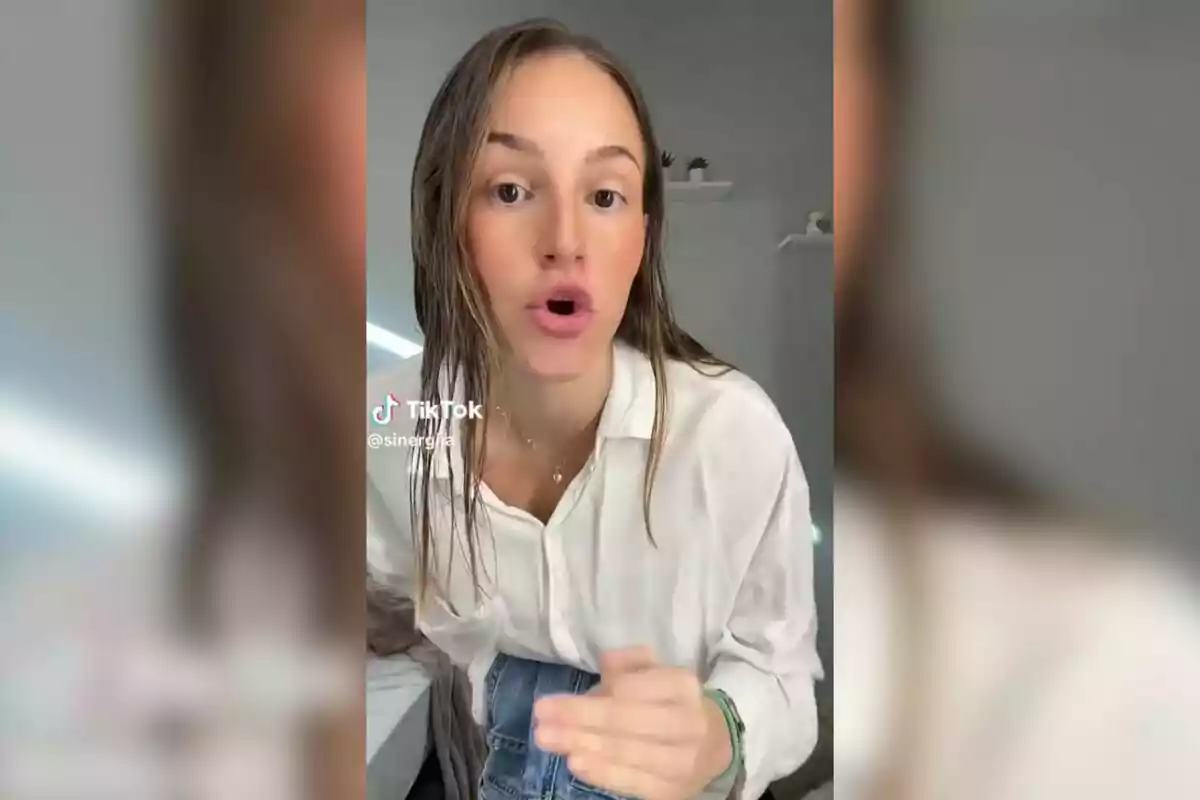 Una persona amb cabell mullat i camisa blanca parla davant de la càmera en un vídeo de TikTok.