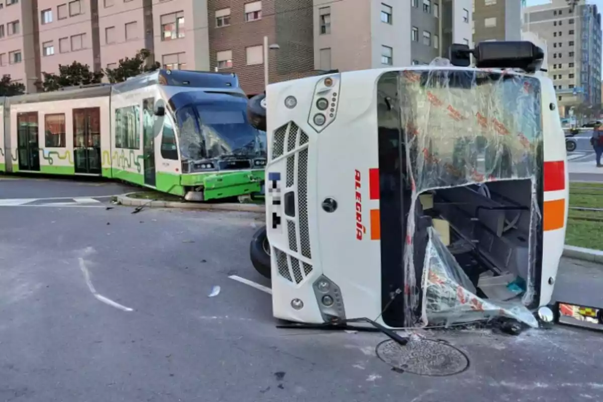 Un tramvia verd i blanc ha xocat amb un autobús blanc consagrat a una intersecció urbana.