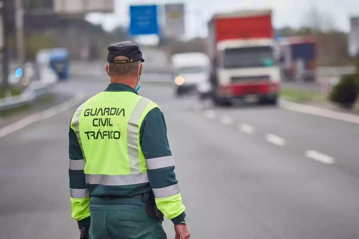 Agent de la Guàrdia Civil de Trànsit a la carretera i amb vehicles de fons